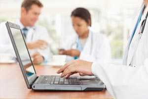 a doctors hands on a laptop keyboard